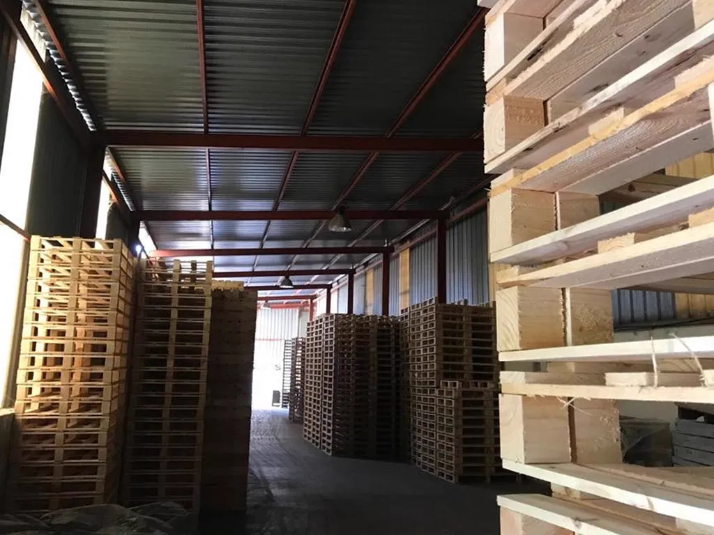 Nave cubierta con pilas de palets terminados